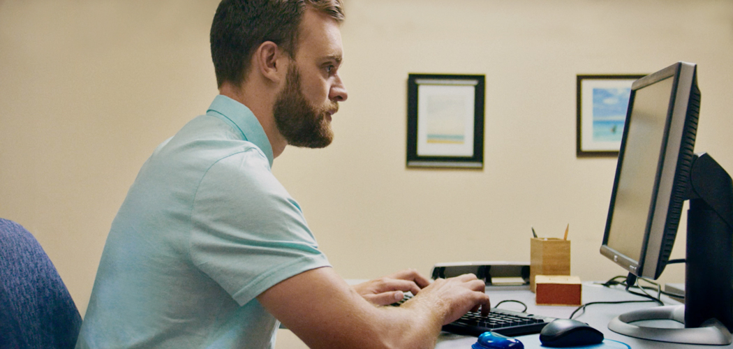 Man uses computer while wearing Air Optix for Astigmatism